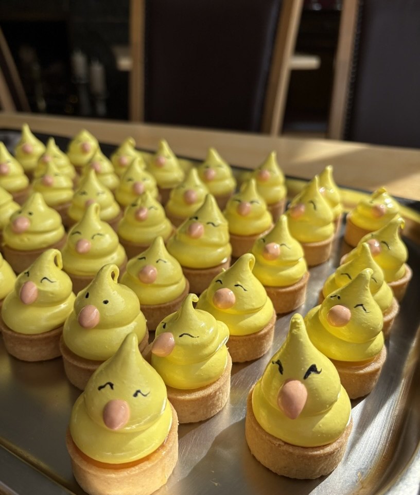 A tray of yellow meringue tarts piped as Easter chicks